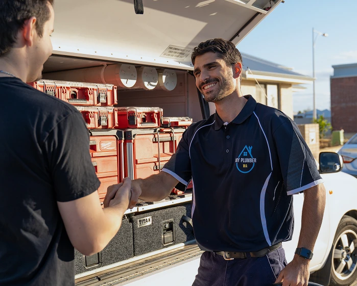 My Plumber WA technician greeting a customer beside a service vehicle in Perth
